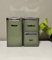 Front view of the set of three green retro tin canisters labeled Flour, Coffee, Tea with chrome lids.