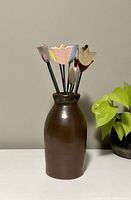 Brown ceramic vase with faux wooden flowers arranged inside, standing about 8.5 inches tall for vase and 13.5 inches tall for flowers.