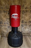 Full view of Wave Master red punching bag with black weighted base.