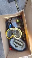 Box view showing multiple diving masks, snorkel tube, and accessories.