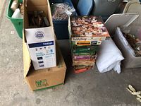 Boxes of jigsaw puzzles stacked showing brand names and piece counts, adjacent packing boxes conceivably containing remote control cars