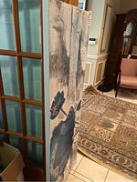Side view showing thickness of gallery stretched canvas and abstract painting with blue and gray flower shapes on white background.