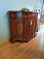 Overall front view showing curved profile, single drawer, three doors and marquetry panels