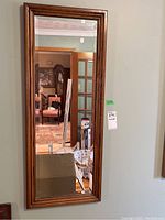 Front view of wood framed beveled mirror showing full reflective surface and frame detail.