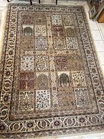 A full view of the Persana rug showing the detailed patchwork classical pattern with multiple floral and decorative blocks and ornate border.