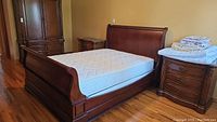 Full view of assembled sleigh bed with mattress in room setting