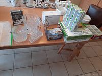 Photo showing assortment including crystal ice bucket, glass napkin holder, glass ice bucket, metal wine rack, Buzzed drinking game box, stacked Bohemia glasses, Polo shot glasses and onion soup bowls on table.