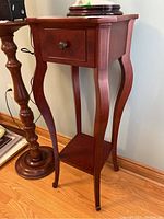 Side view of wood table stand showing drawer, legs, and lower shelf