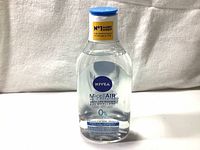 Clear plastic bottle of Nivea MicellAIR Skin Breathe makeup remover with blue cap, shown against a white fabric background.