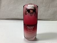 Photo of the sealed Shiseido Ultimune serum bottle with a red gradient design and the price sticker showing $51.00 on the cap.