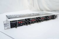 Front angle view showing brushed silver rackmount panel, headphone outputs, knobs and buttons, LED meters, and input/output jacks of Behringer PowerPlay Pro-XL HA4700.