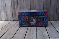 Front view of a decorative box with an eye and mechanical gears design on the front panel.