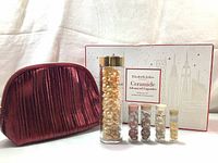 Gift set items arranged with box and cosmetics bag showing all capsules and packaging