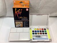 Box packaging and open sketch box showing 18 paint colors and mixing palette lid