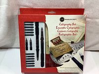 Box packaging of the Manuscript calligraphy starter set showing the included pens, nibs, instruction manual, and ink cartridges.