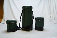 Three Sigma green protective lens bags for Nikon lenses arranged side by side on white background, showing size differences