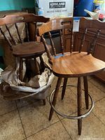 Three vintage wooden barrel back bar stools with visible scratches and slight color difference in finish.