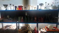 Wide view of shelves holding multiple assorted candles and candle holders, various styles and colors visible