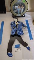 Full view of Elvis Presley themed moveable hips wall clock lying flat.