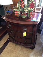 Full view of the petite wooden dresser nightstand with three drawers, curved front, and dark wood finish.