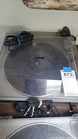 Top view of Realistic Lab-330 turntable with dust cover, power and audio cables coiled on top and inside the unit.