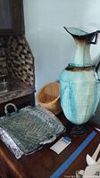 Photo showing the large hand-made ceramic vase with metal-colored gradient and the wicker basket behind, with the ceramic serving tray in front.