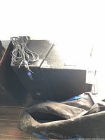 Two black Rockville speakers stacked with cables and stands visible, showing size and overall condition.