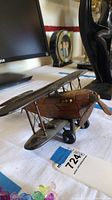 Side view of wooden biplane showing worn propeller and detailed wing struts.