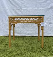 Front view of bamboo and glass table showing natural bamboo frame and clear glass top.