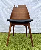 Front view of walnut bentwood dining chair with black vinyl seat.