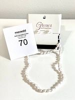 Freshwater pearl necklace, bracelet, and stud earrings set displayed with an auction lot number tag and Glynyz packaging.