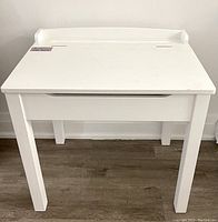 Front view of the white Melissa and Doug children's desk showing the overall structure and condition.