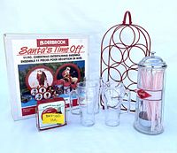 Full view of the Santa's Time Off set in box, red metal wine rack, three Coca-Cola handled glasses, Coca-Cola glass straw dispenser with pink straws, and coasters.