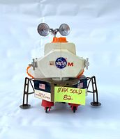 Front view of the vintage Apollo Lunar Module toy showing NASA logo, landing legs, and satellite dishes.