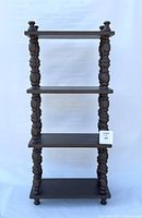 Full front view of the vintage brown painted tall shelf showing all four shelves and turned supports.