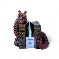 Front view of both chalkware bookworm bookends showing red and brown colored worm wrapped around faux books with gold detailing