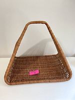 Front view of the triangular wicker basket highlighting the open basket area and handle.