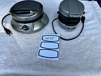 Photo of the front and top view of both Hamilton Beach waffle iron and breakfast sandwich maker placed on a white towel.