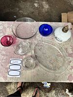 Top view of nine glassware pieces including Pyrex dishes and colorful bowls on table