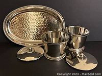 Photo of the silver hammered finish tray and two matching jars with lids on white background; jars are separate from the tray with lids beside them showing design.