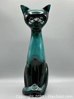 Front view of the tall ceramic cat figurine showing the green and black glaze with a glossy finish and stylized features.