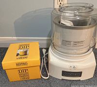 Cuisinart ice cream maker next to the yellow box for the Bistro Dip Chiller, showing both items in the lot