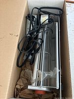 Exhaust blower motor in original box with power cord and blower fan visible.