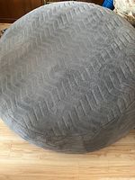 Top view of the round gray bean bag chair showing chevron textured fabric surface and even cushioning.