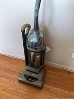 Full upright view of the Hoover vacuum cleaner showing main body, handle, dust bin, and attached hose.