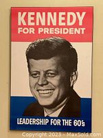 Front view of the fibreboard plaque showing John F. Kennedy's portrait and campaign text in red, white, and blue.