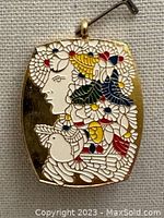 Front view of the rectangular enamel pendant or pin showing a profile of a woman's face, a white dove, and colorful floral enamel decoration.