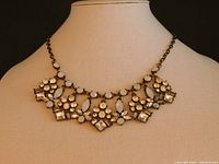 Front view showing the necklace on a display bust with the pendants hanging down along the neck area.