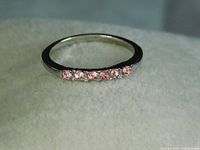 Front view of the vintage pink cubic zirconia ring showing six faceted stones in the silver-toned band.