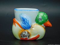 Side view of hand-painted duck-shaped porcelain egg cup with vibrant colors and glossy finish.